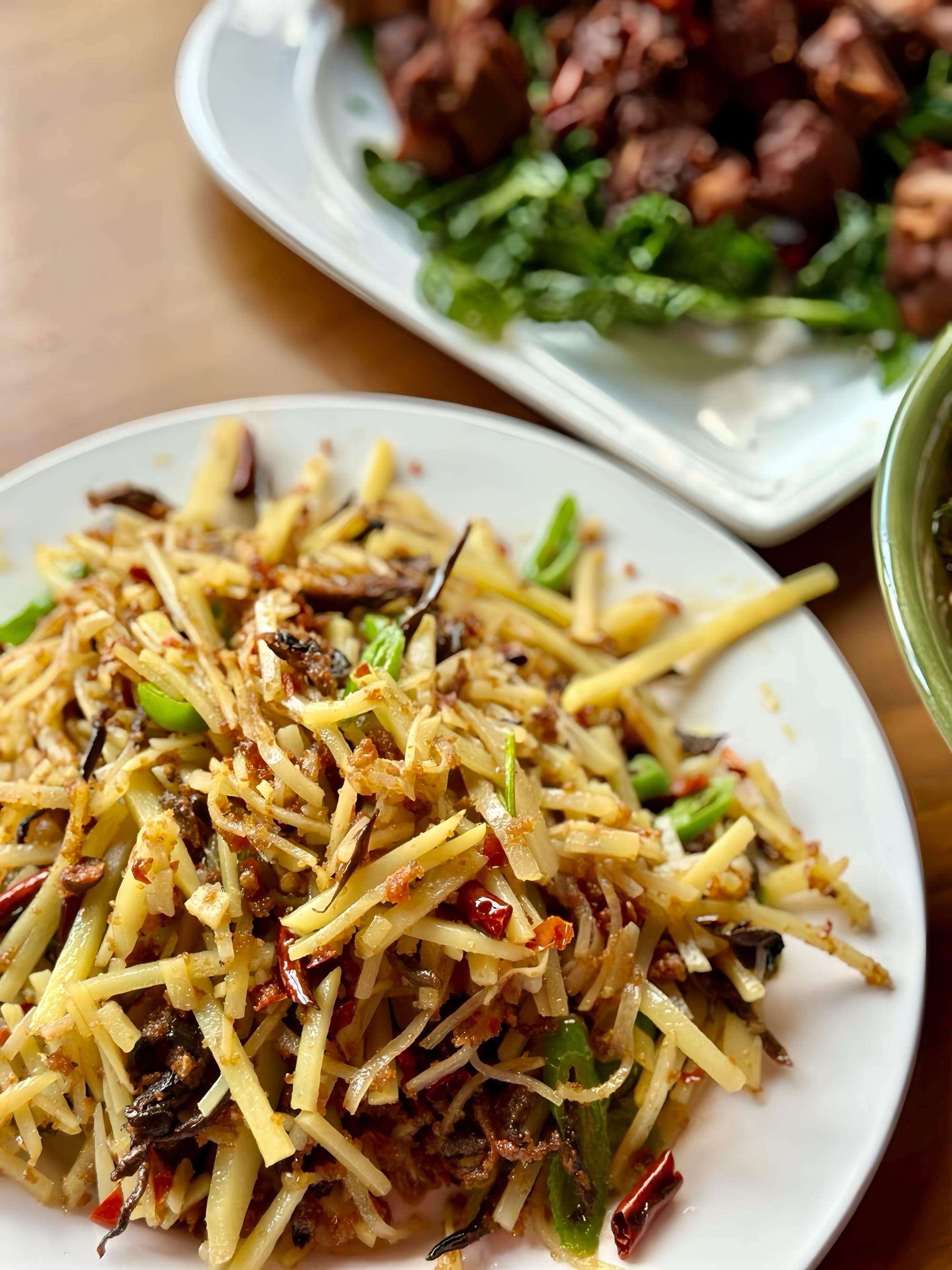 Diced potato and zha mixed into a stir-fry-style dish on a white plate.