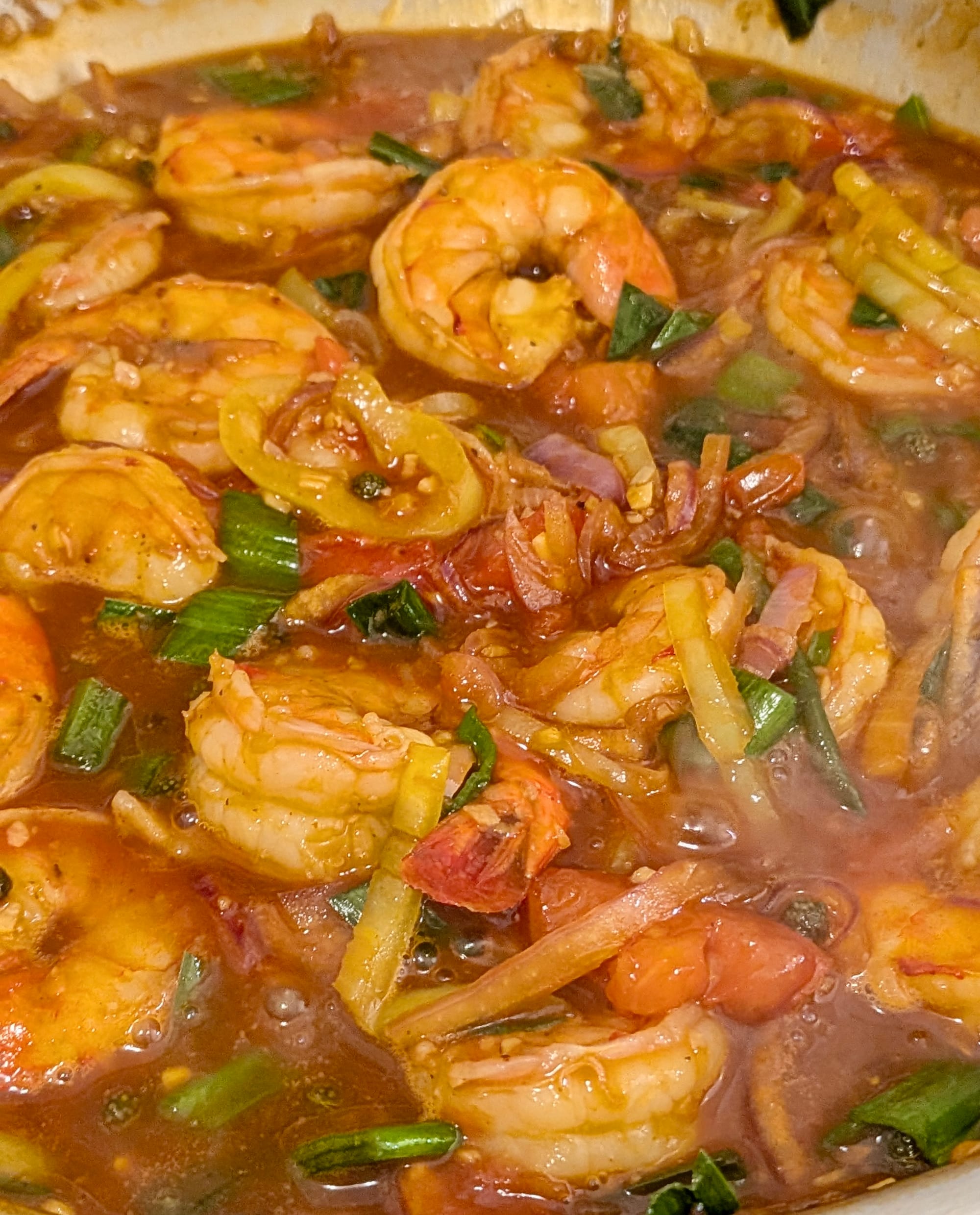 Close up photo of prawns cooking in mixed vegetables and a mala devilled sauce.