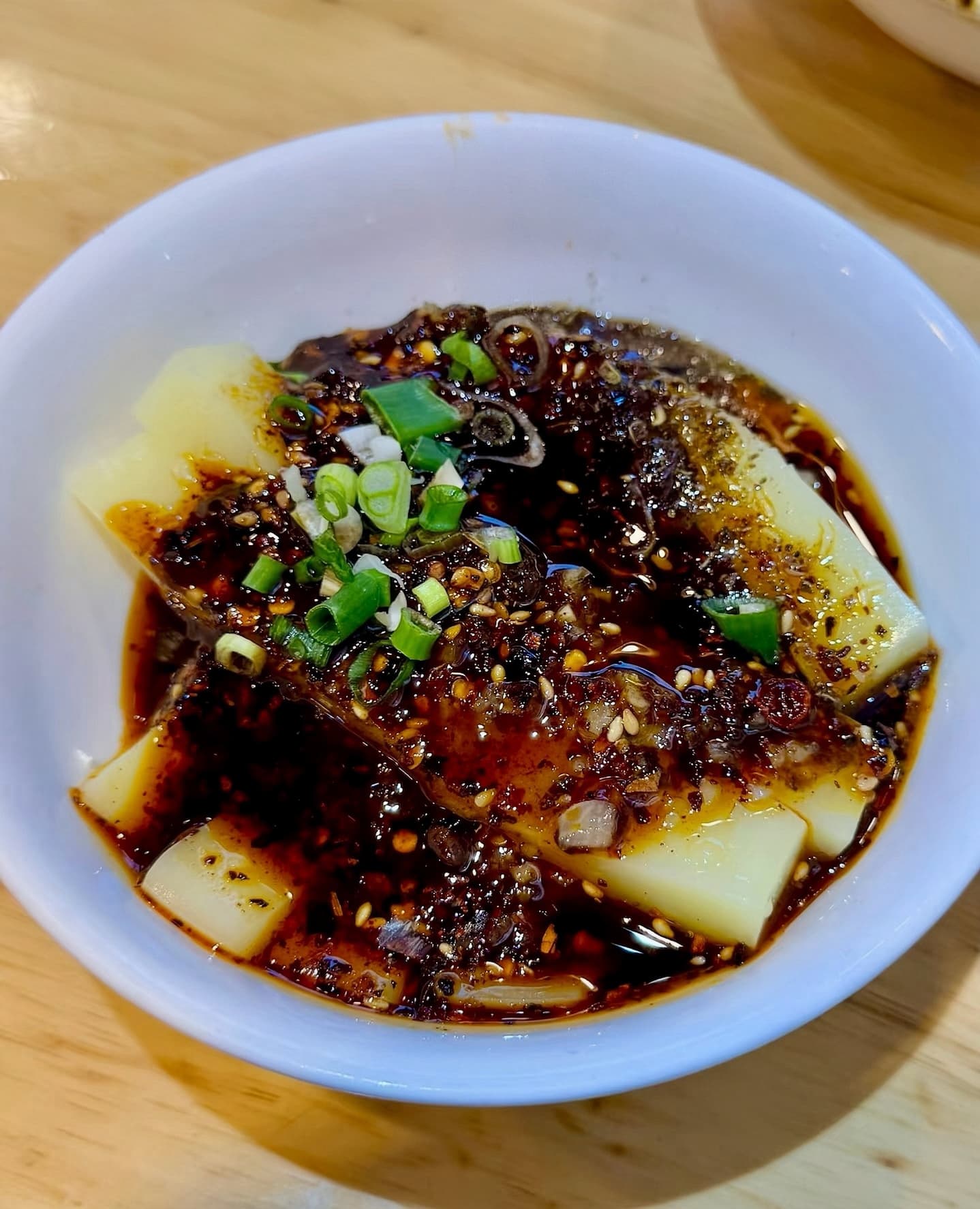 White sticks of roughly 1 cm by 10 cm of rice smothered in a spicy deep red sauce.
