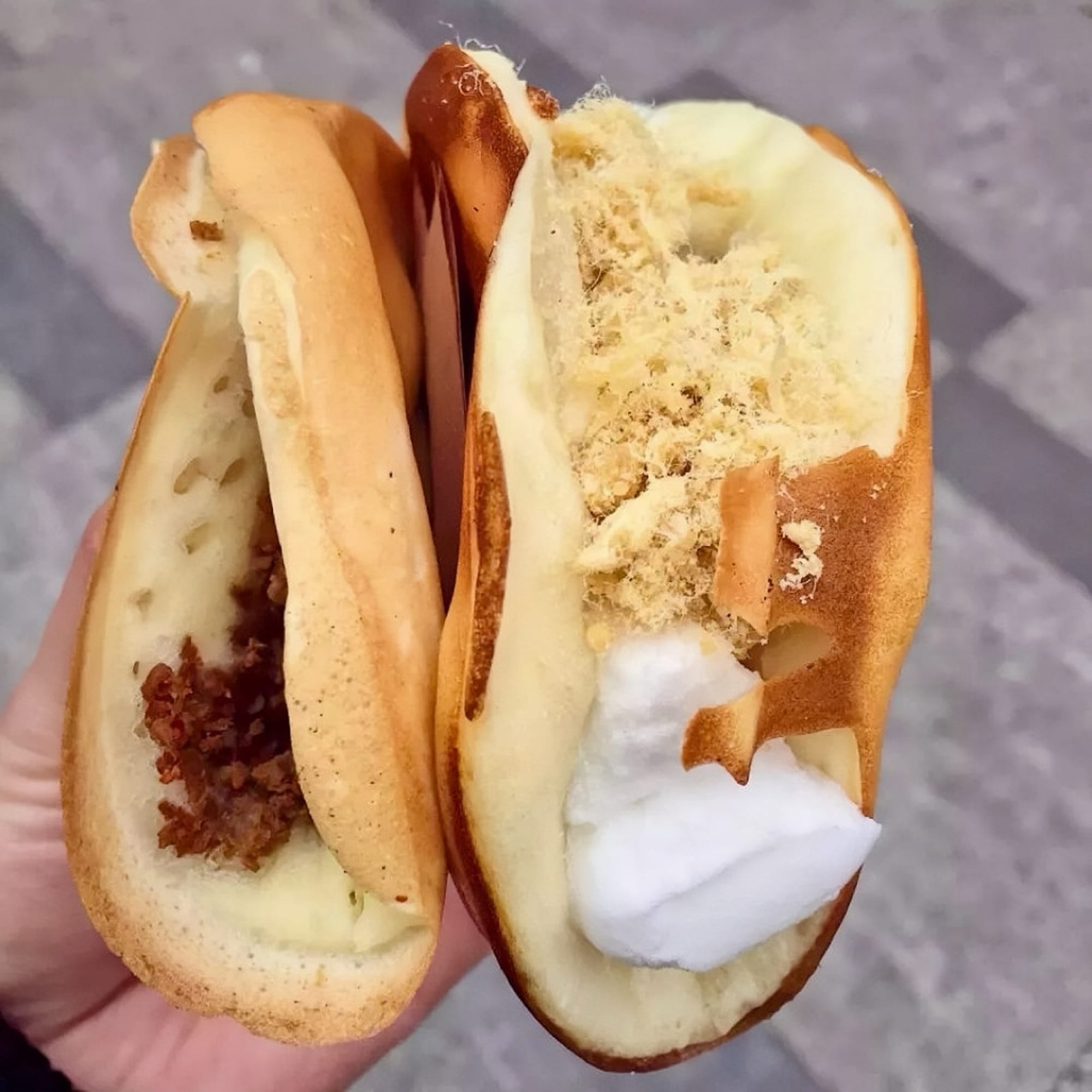 Two Chinese crepes, folded like tacos, one filled with whipped cream and pork floss, the other caramelised pork chunks