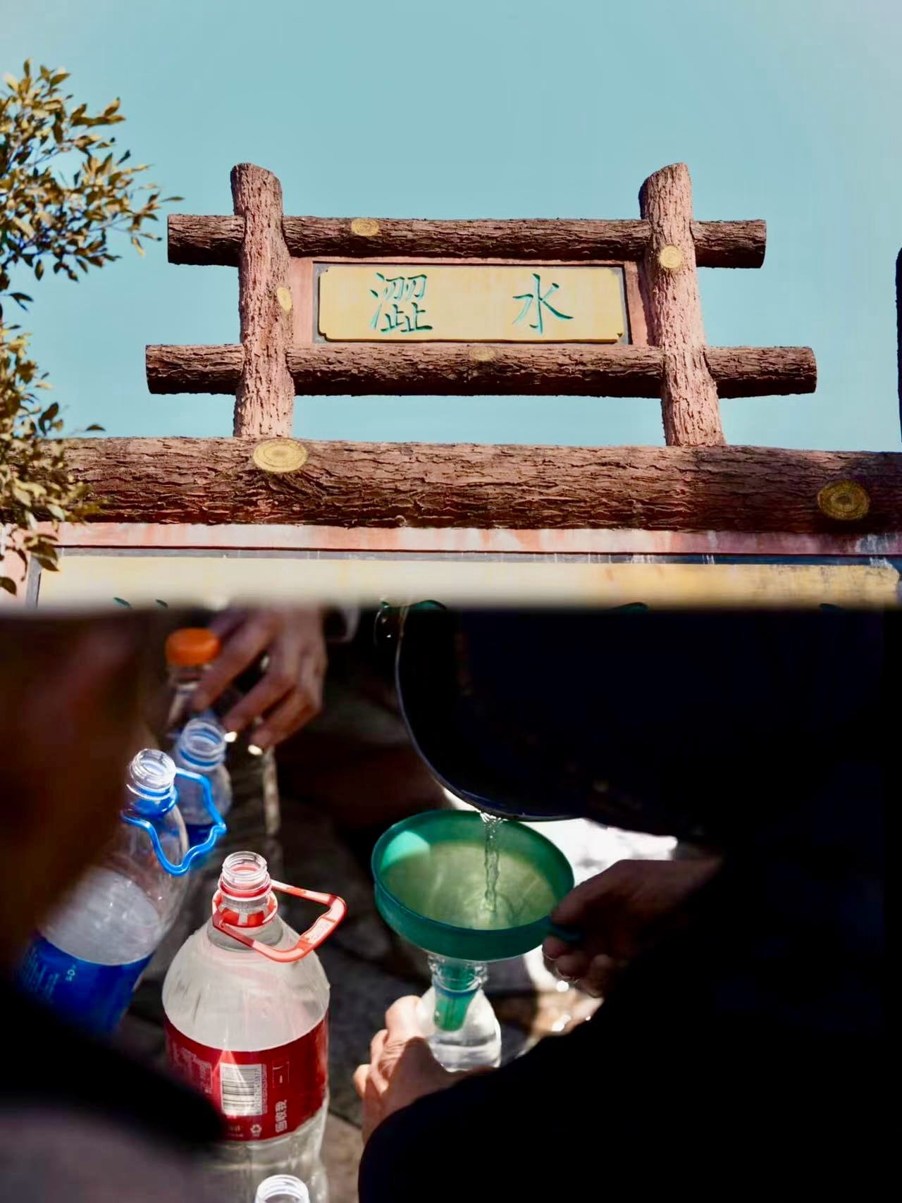 Locals gather at a local spring to fill up their water bottles underneath a big man-made wooden arch to signal the spring