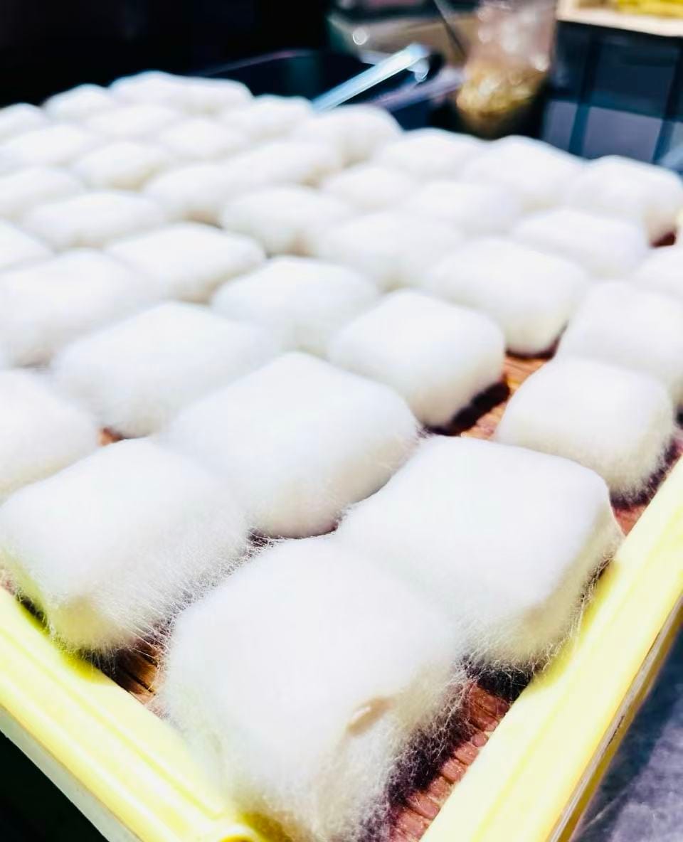 A wooden tray containing the white fluffy cubes of furu tofu.