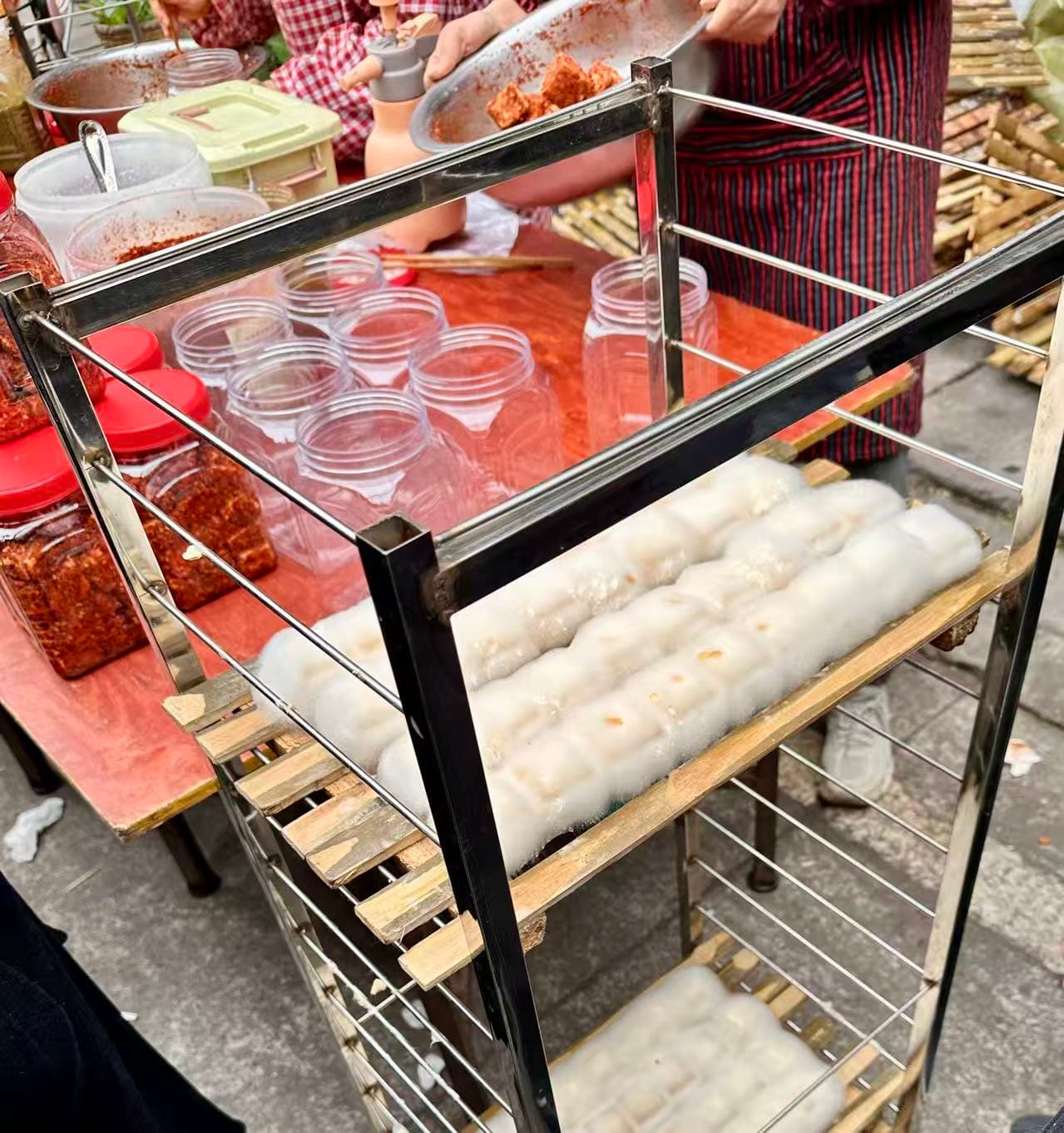 Furu tofu, white and fluffy trays of tofu sit stacked at a street vendor's stall.