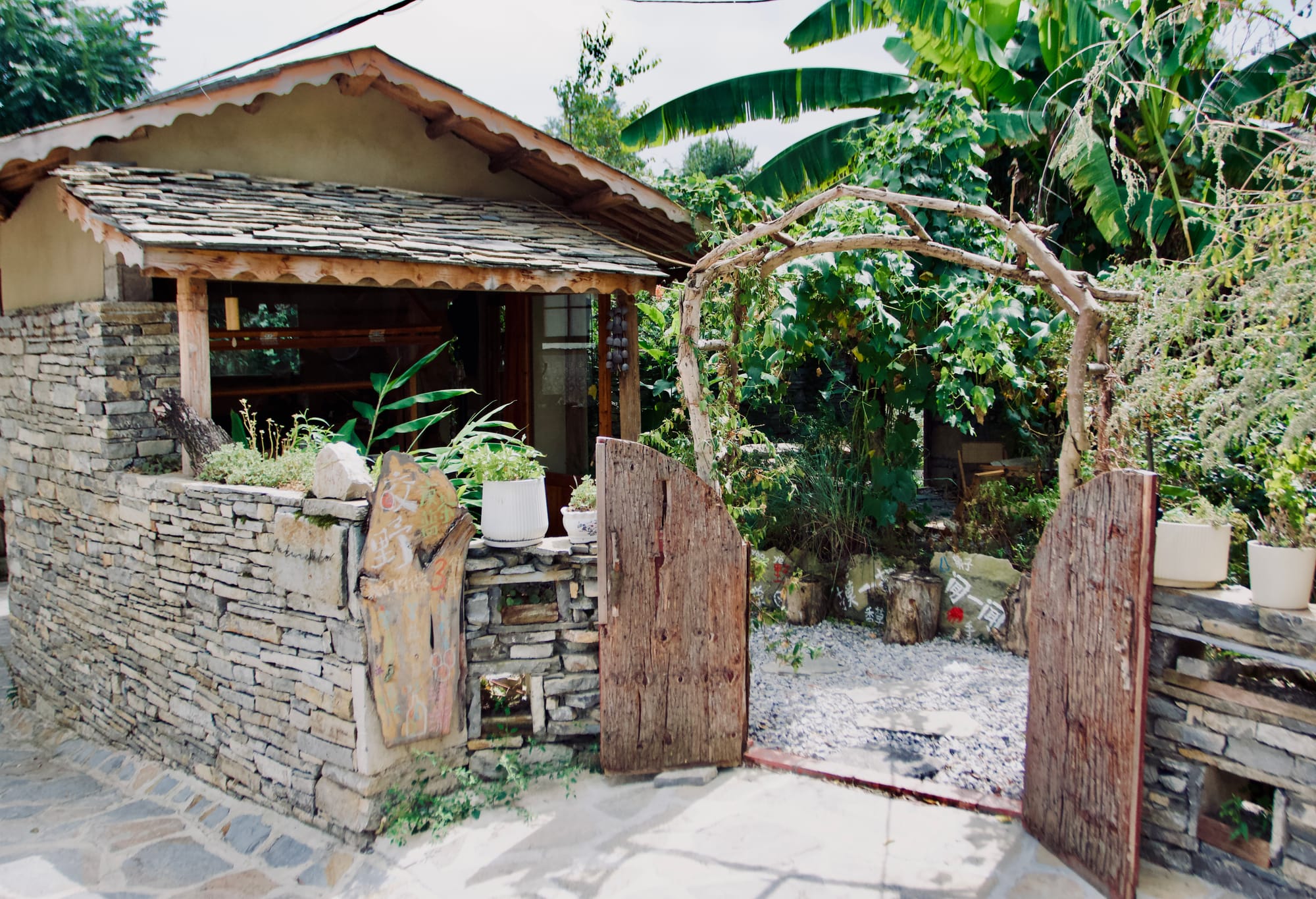 A small, hipster yard with stone walls and a wooden set of double doors.