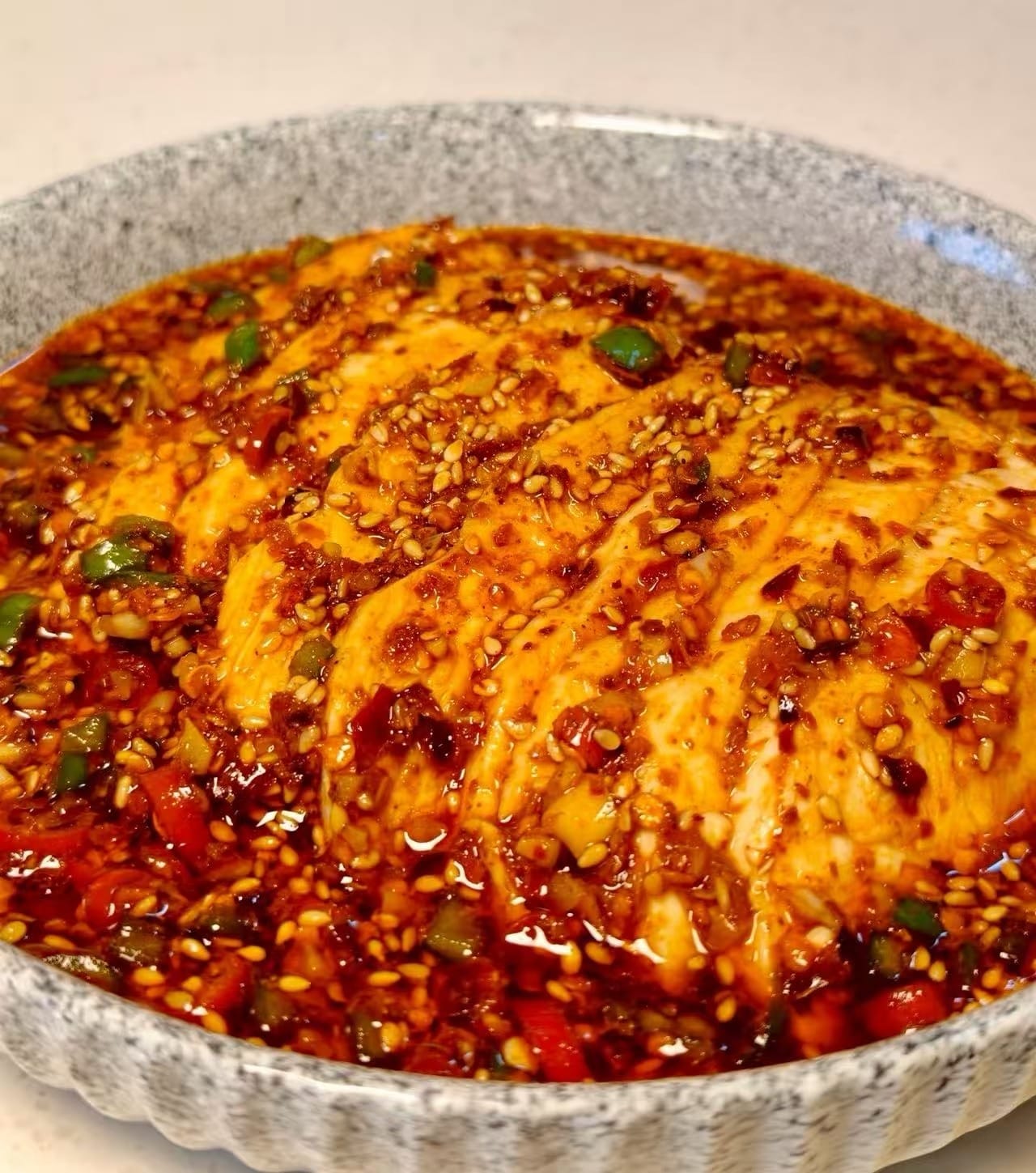 Slices of chicken covered in red chili oil