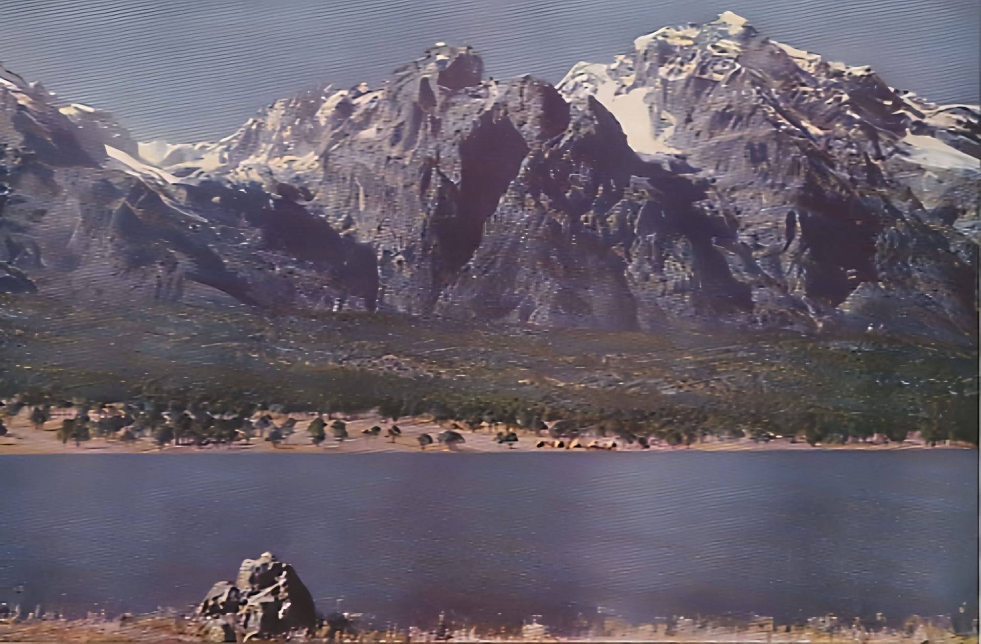 A scan of an old painting of rocky mountains in Yunnan before a forest and river in the foreground.