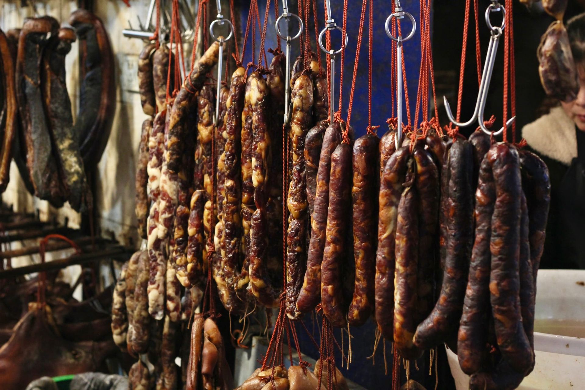 Sichuan sausages hanging on hooks in a local market in Luzhou, Sichuan, China.
