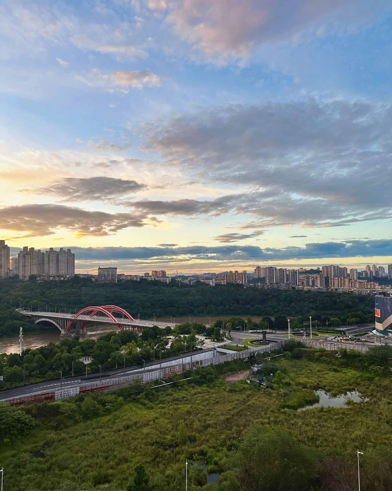 The modern sprawl of Luzhou, flanking the Yangtze river with a simple modern arch-style bridge connecting two sections of the city.