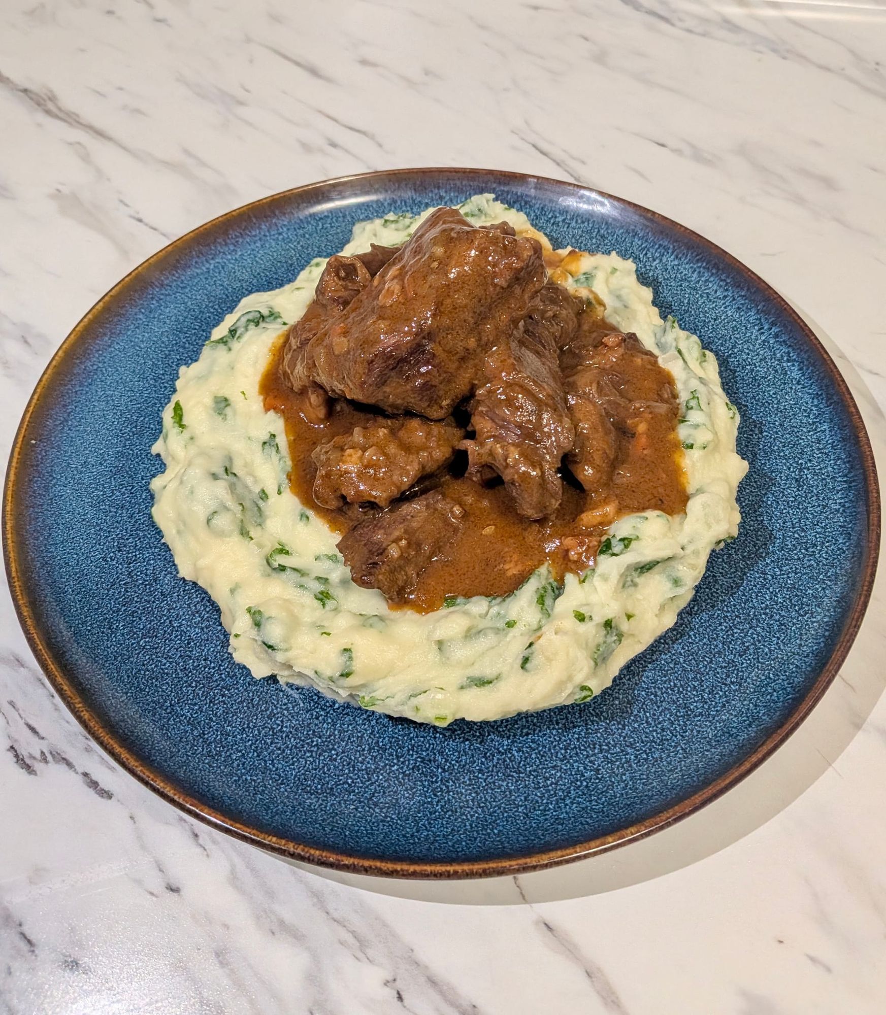 Stoofvlees with Stamppot - a beef stew atop a bed of mashed potatoes with kale.