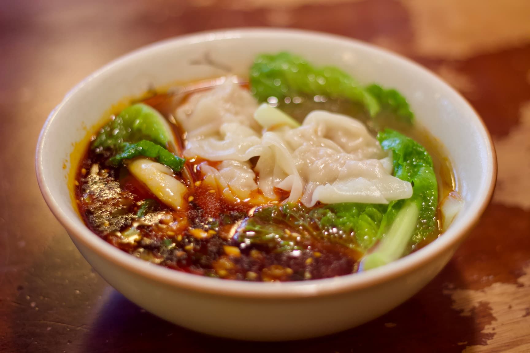 White wontons in Doubanjiang Broth with lettuce leaves