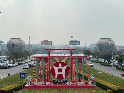Two building-sized baijiu urns flank the roads leading to and from the Luzhou airport. In the centre is a big red sign welcoming people to Luzhou.