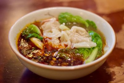 White wontons in Doubanjiang Broth with lettuce leaves
