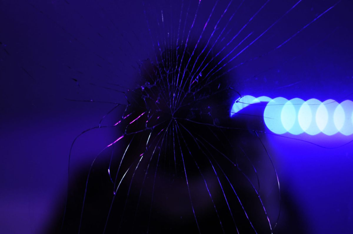 white woman with a camera reflected in a broken mirror