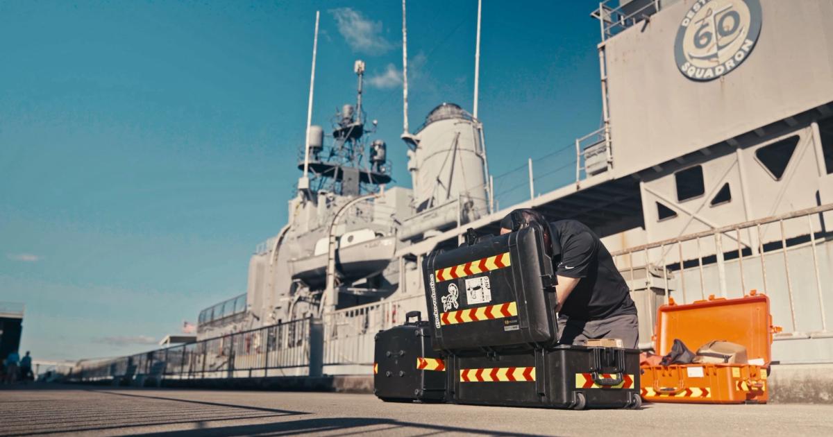 Gecko Robotics team with inspection equipment beside a Navy ship