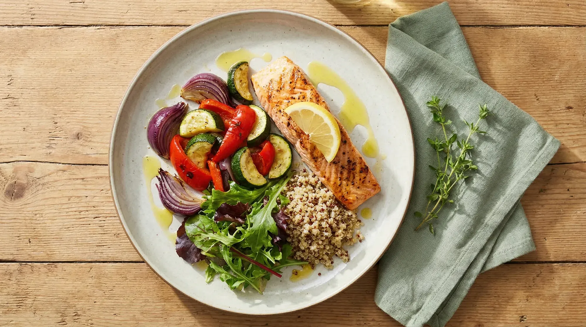 Mediterranean fertility meal with grilled salmon, roasted vegetables, and leafy greens on a cream plate