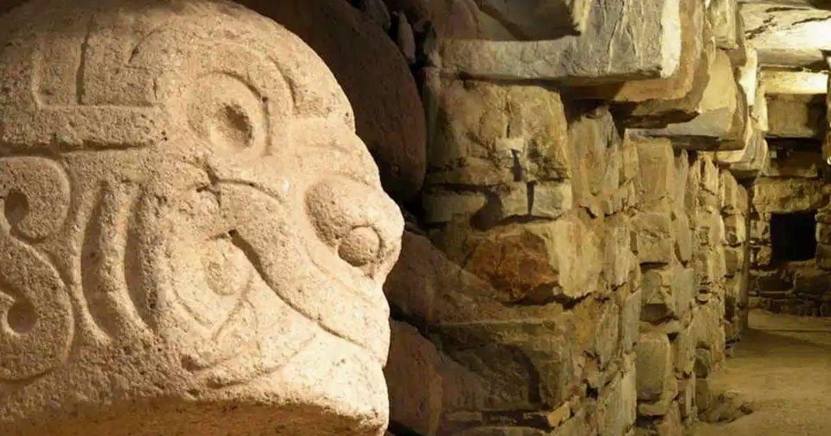Carved stone tenon head with swirling features inside the underground gallery at Chavín de Huántar in Peru