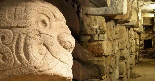 Carved stone tenon head with swirling features inside the underground gallery at Chavín de Huántar in Peru