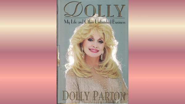 Cover of My Life and Other Unfinished Business featuring Dolly Parton and gold font, on faded background of whites and pinks