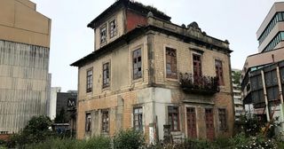 Prédio devoluto com fachada degradada numa rua do Porto