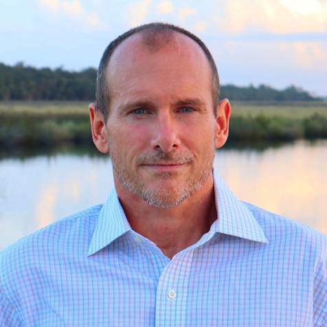 A person standing in front of a body of water

AI-generated content may be incorrect.