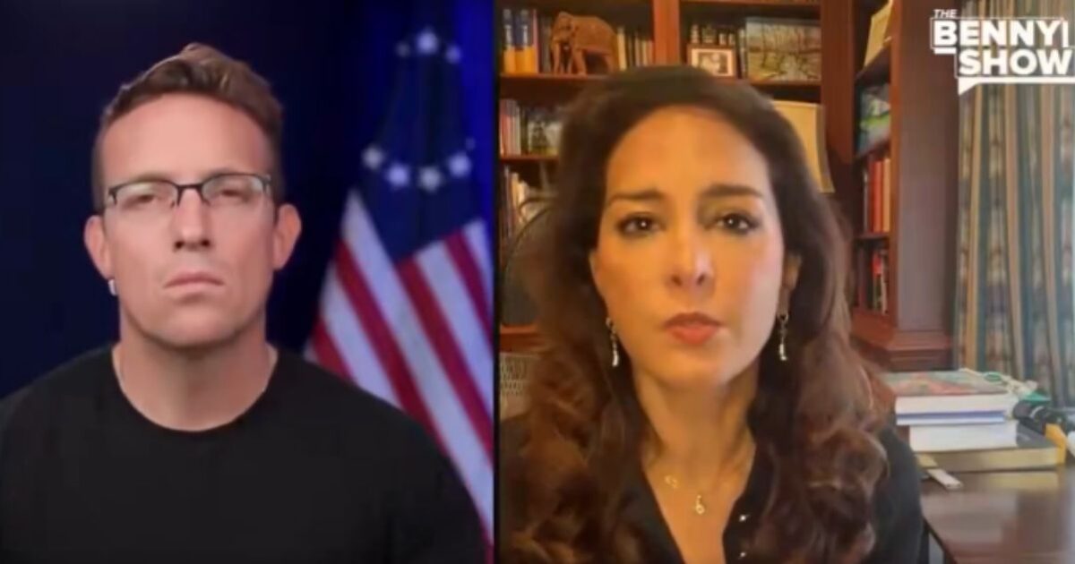 Two hosts discussing current events on The Benny Show, with a backdrop of bookshelves and an American flag.