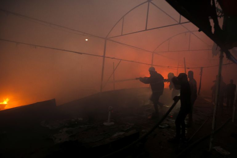 People attempt to extinguish a fire at the site of an Israeli strike on tents sheltering displaced people, amid the Israel-Hamas conflict, in Deir Al-Balah in the central Gaza Strip, October 14, 2024. REUTERS/Ramadan Abed