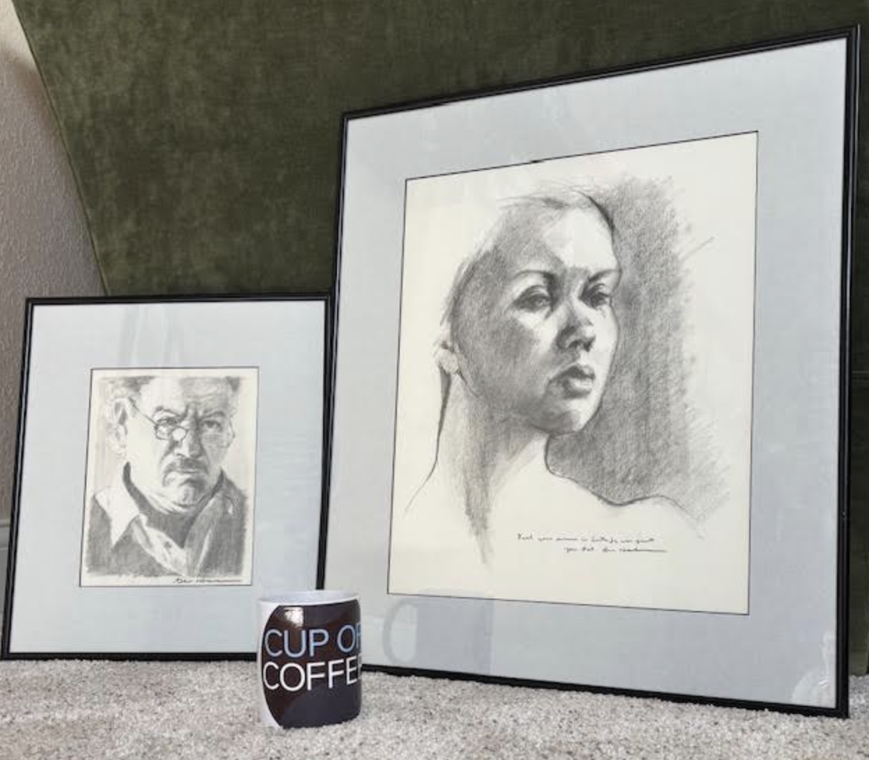 Two pencil drawings by Gene Hackman: one a self-portrait and the other, larger, a drawing of his wife, Betsy Arakawa, with a Cup of Coffee coffee mug in front of them