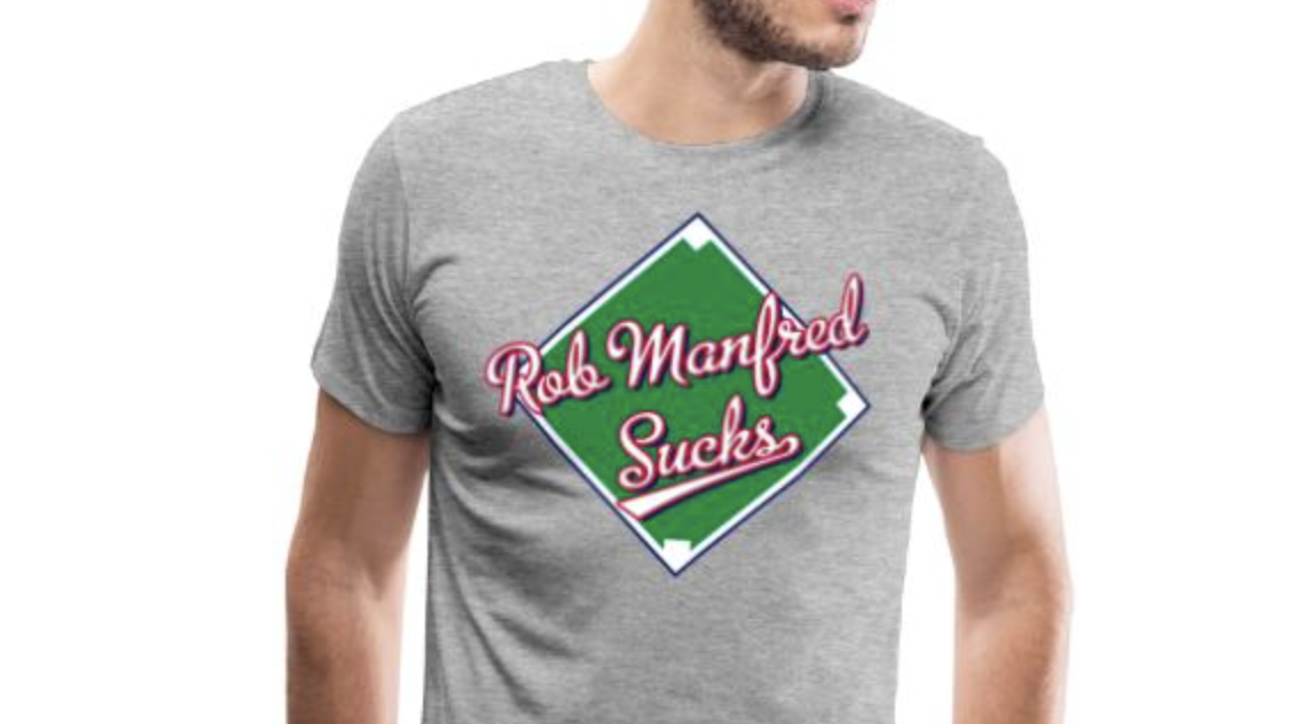 Gray T-shirt that has the script words "Rob Manfred Sucks" over a green baseball diamond