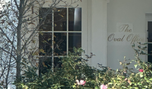 The White House with a sign on the wall -- cursive writing on actual paper -- that says "The Oval Office" 