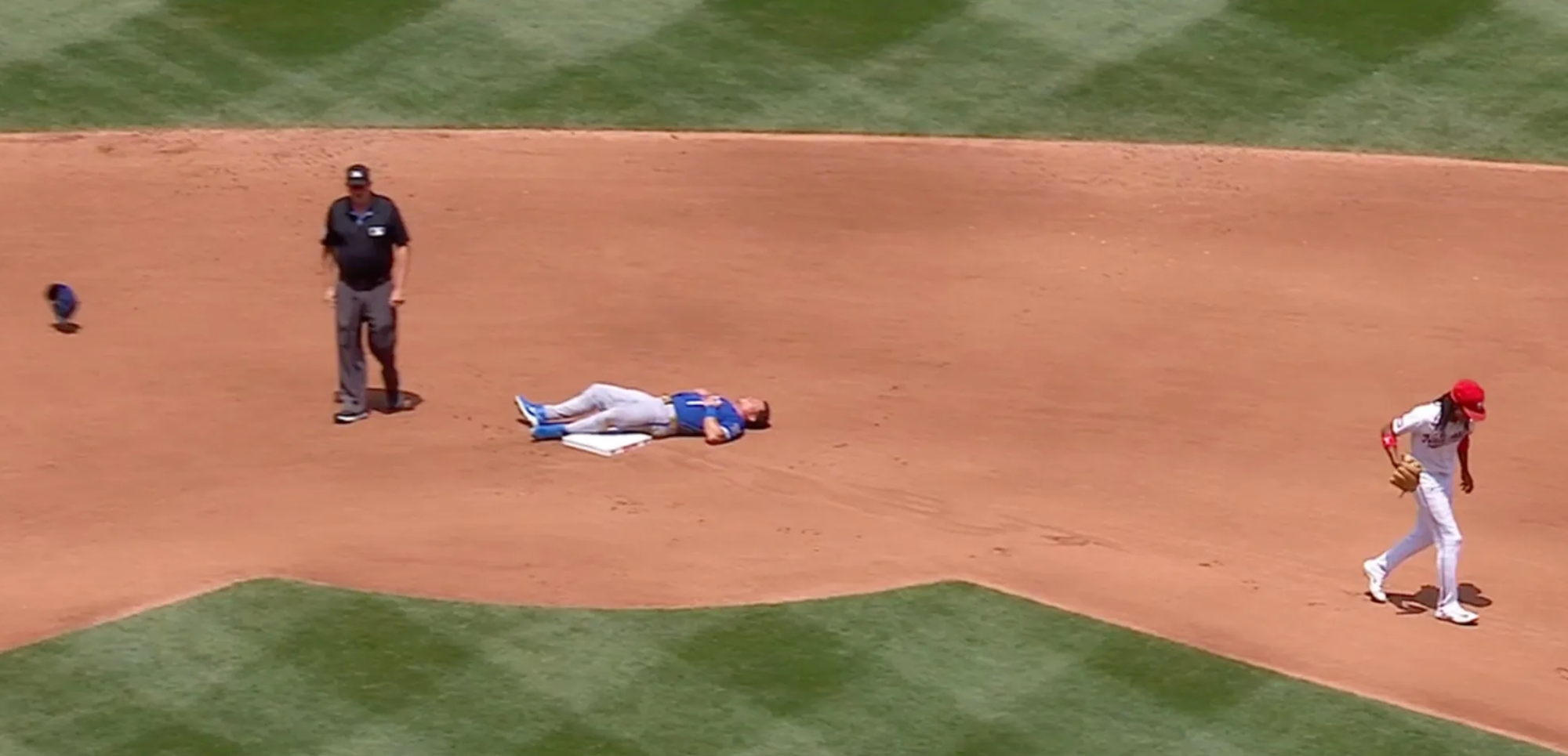Isaac Collins laying out like a dead body on the second base bag while the Nationals infielder and the umpire walk in after the end of an inning
