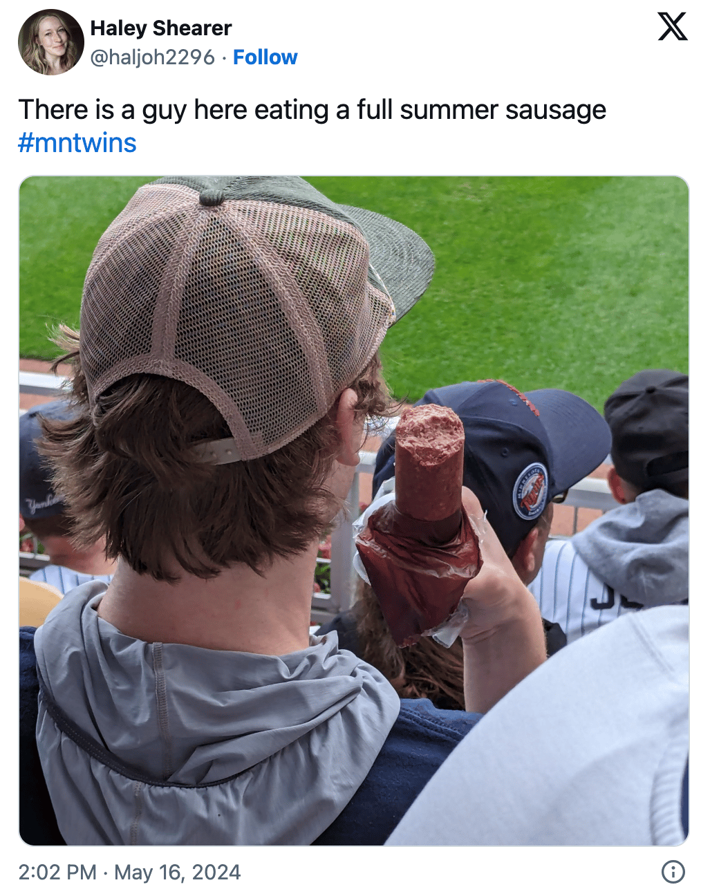 Tweet of a guy in the stands eating an entire summer sausage