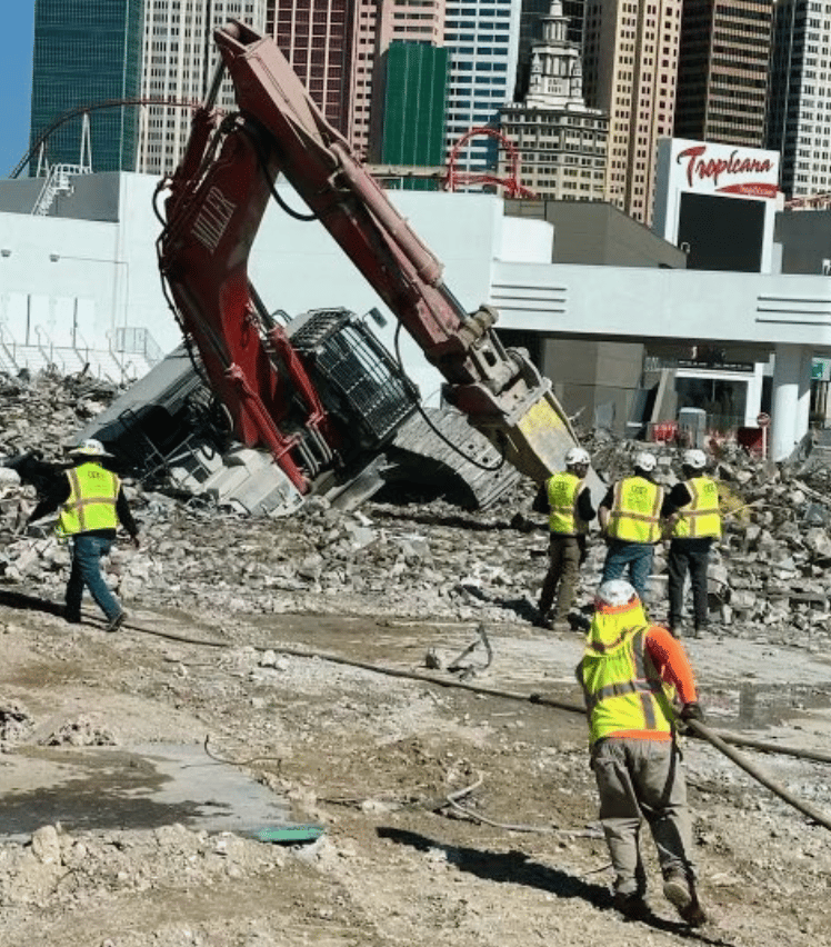 Large construction backhoe sunk halfway into the ground
