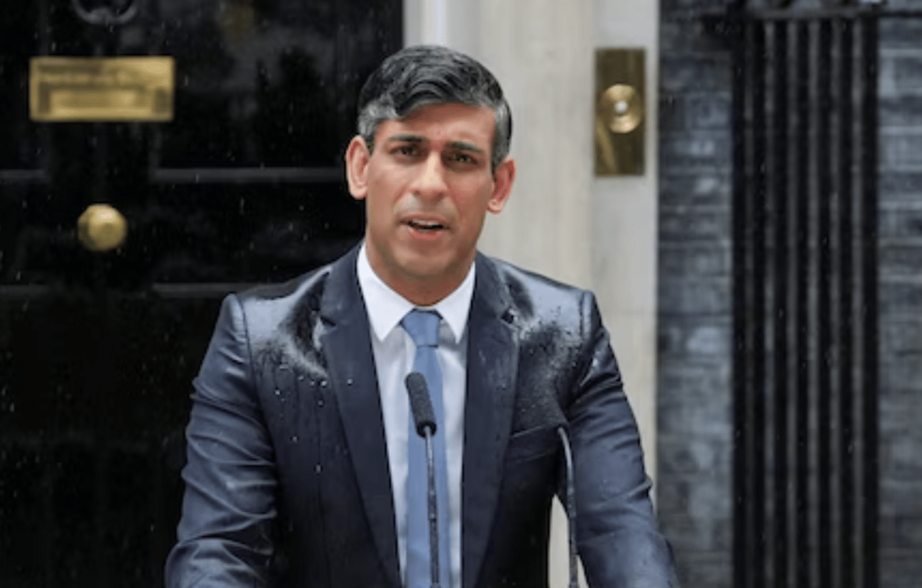 Rishi Sunak making a speech in the pouring rain his suit soaking wet