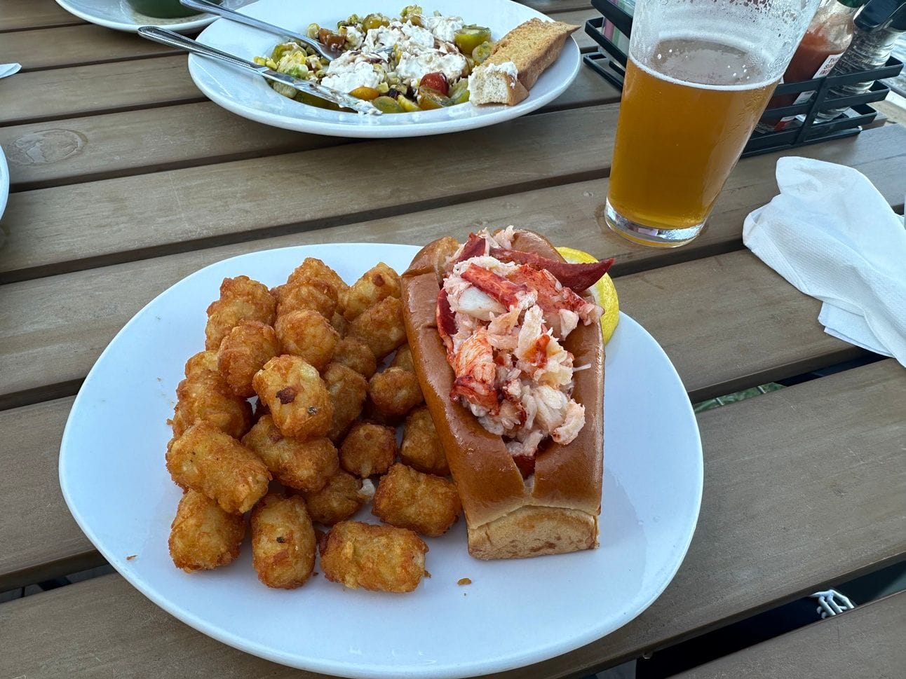 Craig receives a beer, a lobster roll, and tater tots