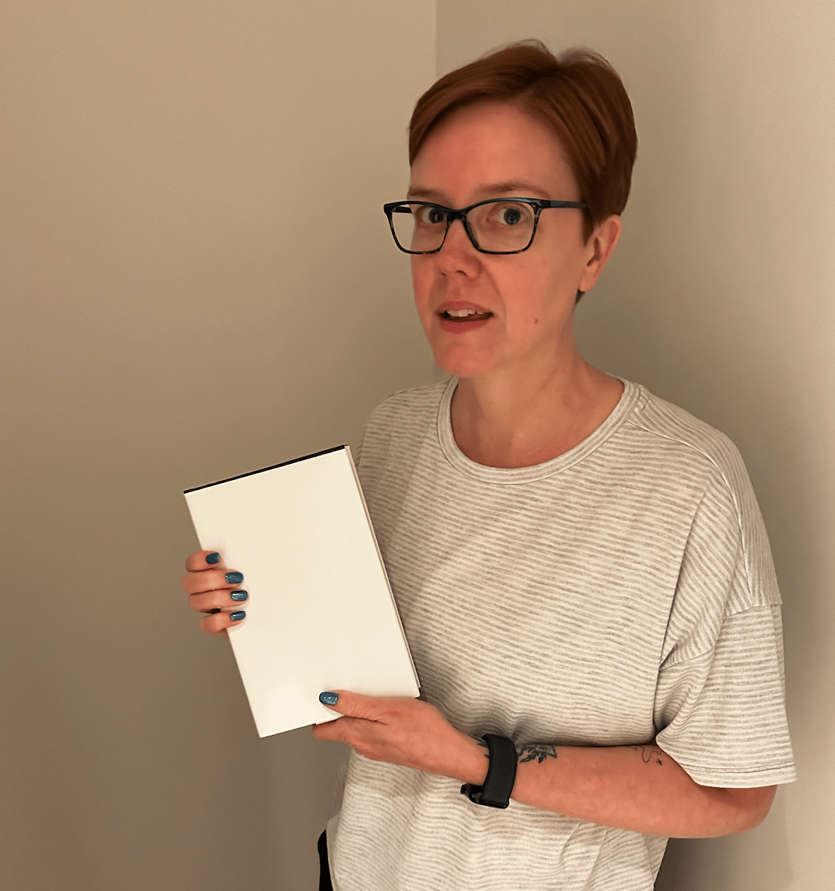 Allison holding up a plain white book