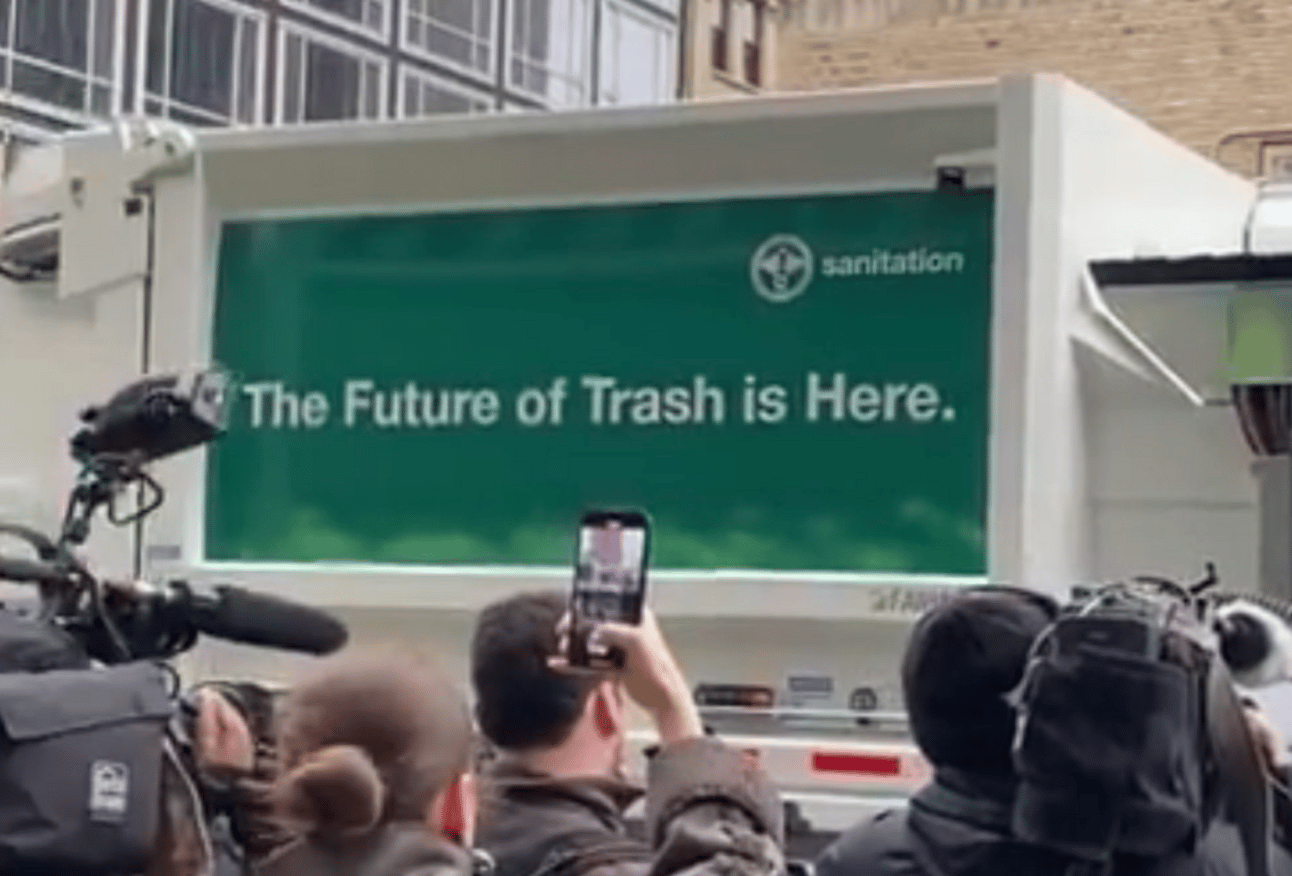 Sign on the side of the truck saying "the future of trash is here"
