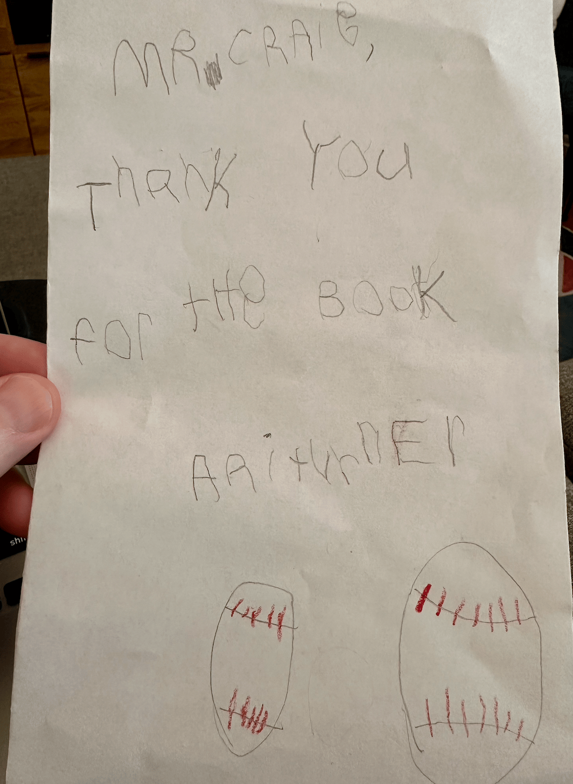 Handwritten note by a child that says "Mr. Craig, Thank You for the book Ari" and it has two hand-drawn baseball underneath that.