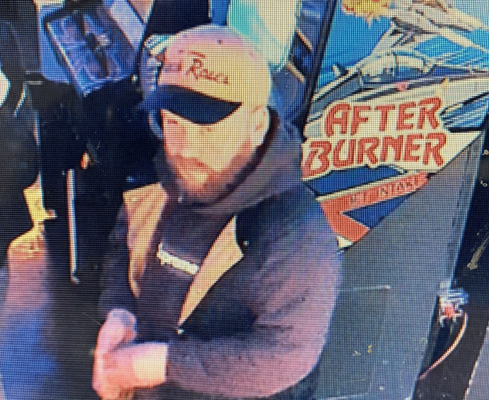 Vandal on security camera walking away, his bearded face and baseball cap with brewery name on it