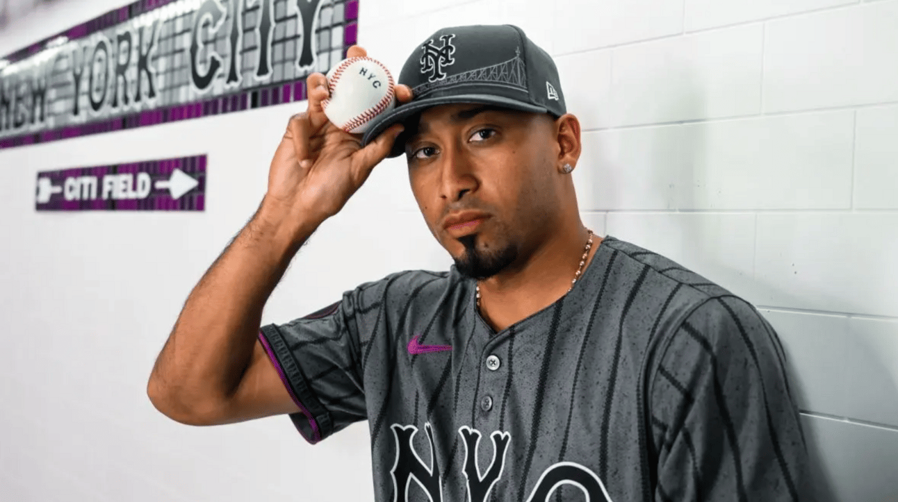 Same jersey but in this photo the cap is move visible: it has a rendering of the Trboro Bridge across the front of Queens