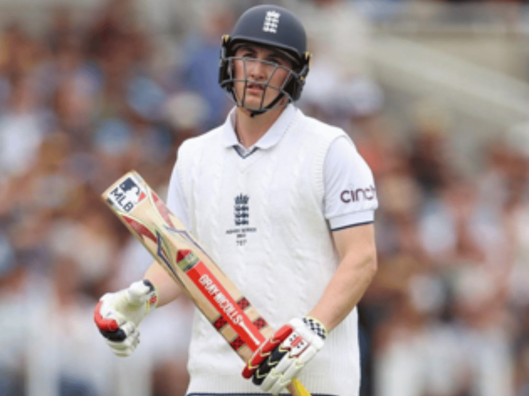 Cricket player with a bat that has an MLB sticker on it