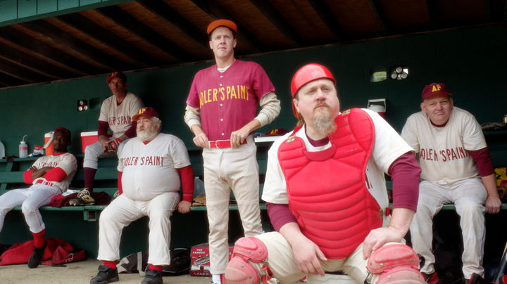 Screencap from the movie "Eephus." Six baseball players in uniform in a dugout, all of whom are pretty old and/or out of shape