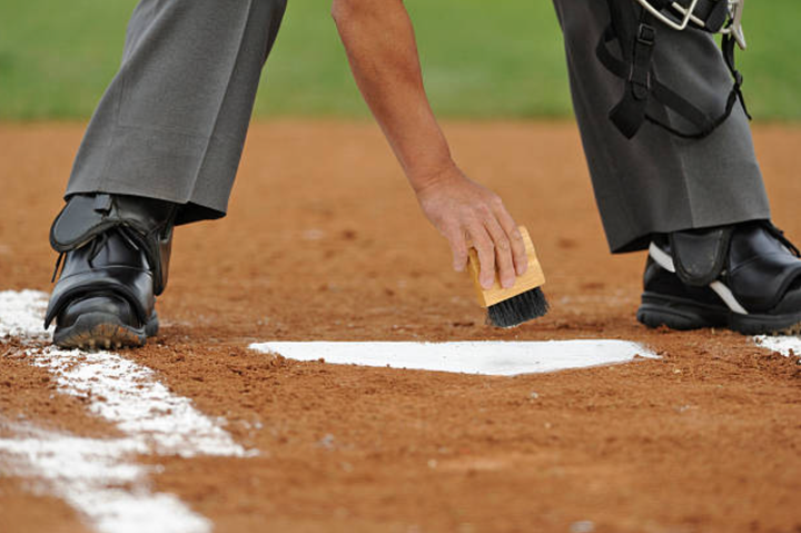 Umpire brushing off home plate