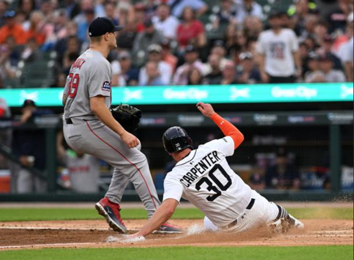 Kerry Carpenter of the Tigers sliding home in front of Tanner Houck of the Red Sox 