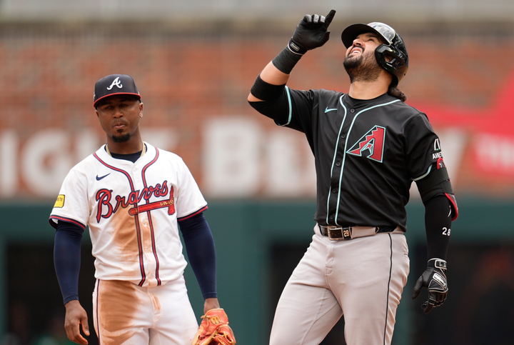 Eugenio Suarez looks up at the sky after hitting a go-ahead double while Ozzie Albies looks on in disappointment