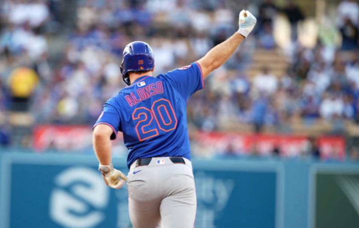 Pete Alonso with his arm up in the air as he rounds the bases after a home run