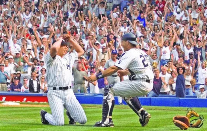 David Cone on his knees, celebrating his perfect game, with Joe Girardi coming to hug him
