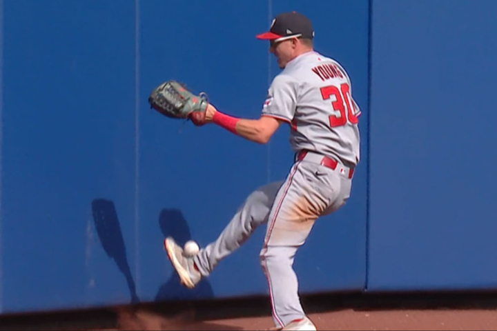 Nationals center fielder Jacob Young kicks a ball up in the air that he eventually catches