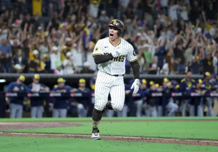 Freddy Fermin pounds his chest and the crowd in the background cheers as he hits a walkoff single which clinched a postseason spot