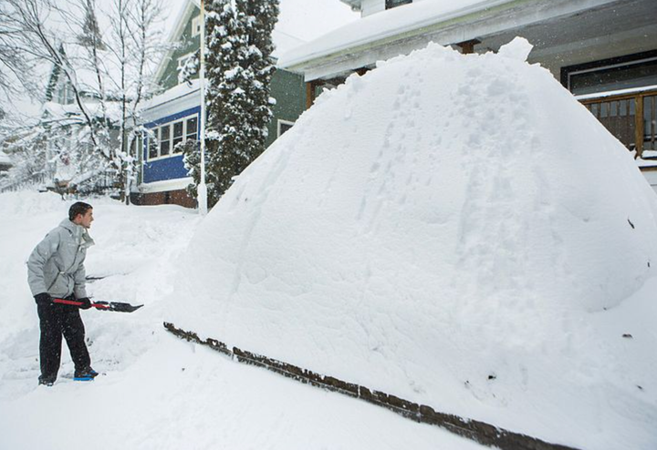 A guy next to a giant snow pile