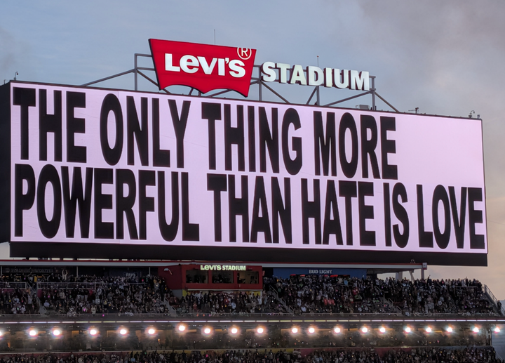 Scoreboard saying "The only thing more powerful than hate is love"